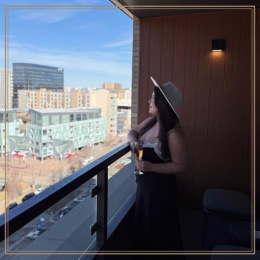 a person on a balcony with a drink in their hand