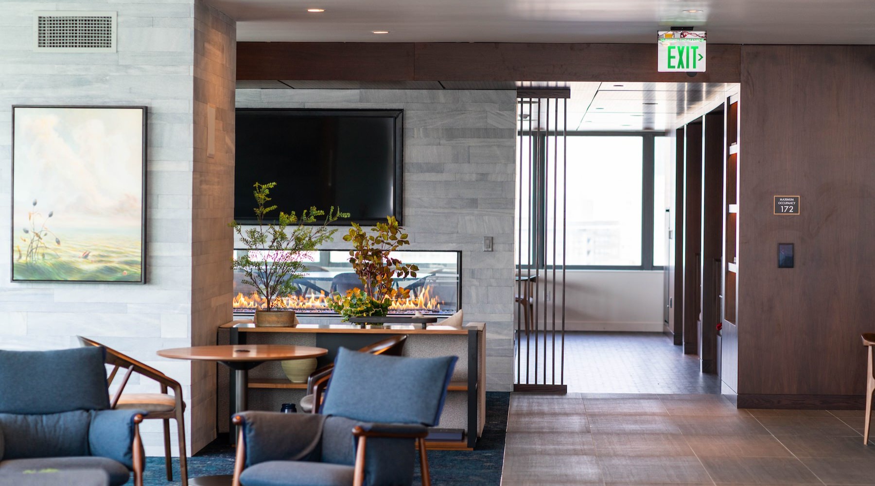 community area with a tv, large windows and ample seating options